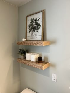 two wooden shelves above a toilet in a bathroom