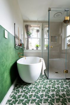 a bath tub sitting next to a window in a bathroom on top of a tiled floor