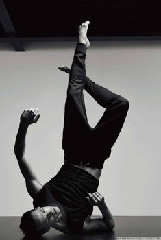 a man doing a handstand on the floor with his feet in the air