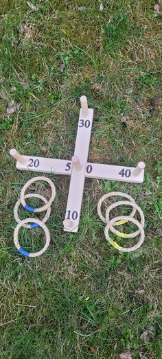 a cross laying on the ground with several rings around it and measuring tape in front of it