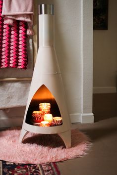 a small white oven sitting on top of a pink rug