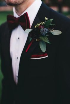 a man in a tuxedo with a red bow tie and boutonniere