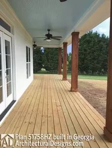 a porch with wooden floors and ceiling fans