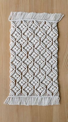 a white crocheted wall hanging on top of a wooden table