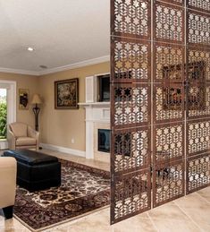 a living room with a fireplace and an ornate screen on the door to another room