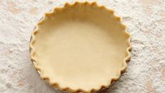 an uncooked pie crust sitting on top of a floured surface with a spoon