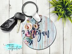 a keychain with the word vegan on it next to two keys and a potted plant