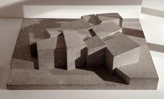 a sculpture made out of concrete blocks on top of a white surface with shadows coming from it