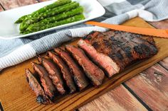 sliced steak and asparagus on a cutting board