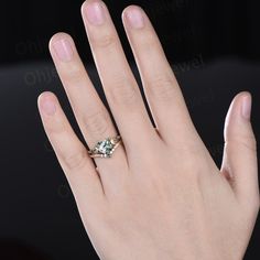 a woman's hand with a ring on it and an emerald stone in the middle