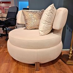 a round chair with pillows on top of it