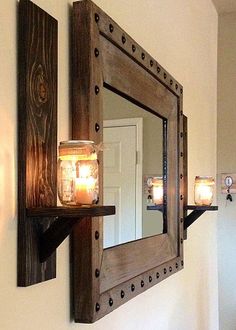 a candle is lit on the wall in front of a mirror and shelf with candles