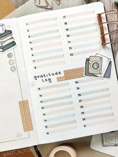 an open planner book sitting on top of a desk next to some books and other items