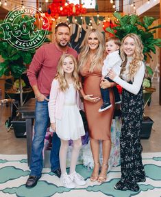 a family posing for a photo in front of christmas decorations