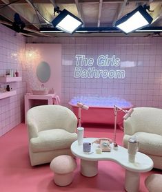 a pink bathroom with two chairs and a bathtub in the corner, all decorated in white