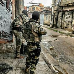 two soldiers are standing in an alley with graffiti on the walls