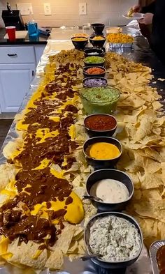 a long table filled with lots of different types of condiments and dips