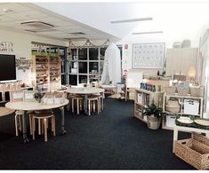 a room with tables, chairs and shelves full of items in it's center