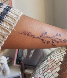 a woman's arm with a tattoo on it that reads, follow love and flowers