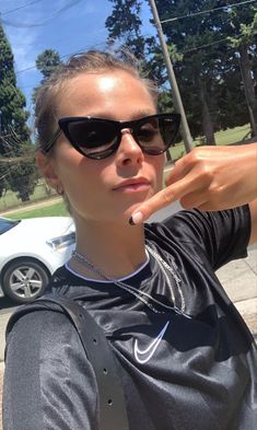 a woman in sunglasses is pointing at something