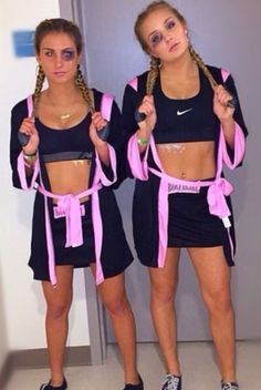 two girls in matching outfits holding up pink ribbons