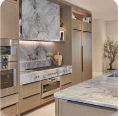 a kitchen with marble counter tops and stainless steel appliances in the middle of the room