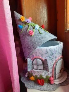 a small house made out of felt with flowers on it