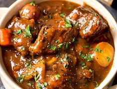 a white bowl filled with stew and carrots