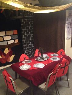 the table is set with red cloths and place settings for four people to sit at