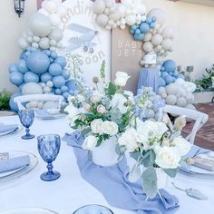 a table set for a baby shower with blue and white decorations