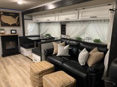 a living room filled with furniture and a fire place in the corner next to a kitchen