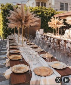 a long table is set up with plates and place settings for an outdoor dinner party