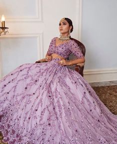 a woman in a purple gown sitting on a chair