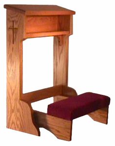 a small wooden desk with a red cushion on it's bottom shelf and foot rest