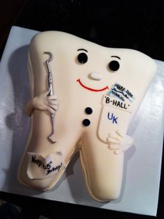 a toothbrush shaped cake with writing on it and a smile drawn on the teeth