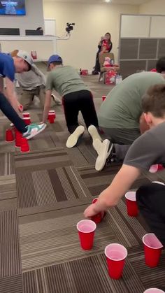 several people are playing with cups on the floor