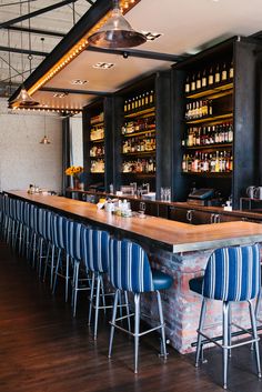 an empty bar with blue and white chairs