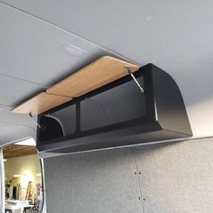 the inside of a vehicle with its door open and an overhead shelf on the side