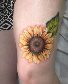 a sunflower tattoo on the left thigh