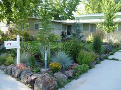 a house with rocks and plants in front of it