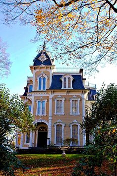 an old yellow house with a blue roof