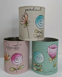 three tin canisters with flowers painted on them