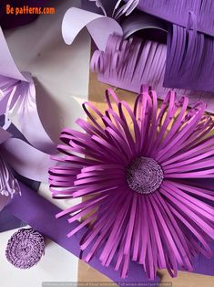 purple paper flowers are displayed on a table