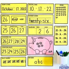 a pig themed calendar is displayed on a white board with markers and pencils next to it