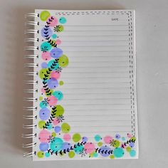 a spiral notebook with colorful flowers and leaves on it, lined in pink, blue, green, yellow and white paper