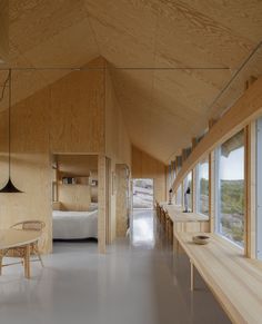 the interior of a wooden house with large windows