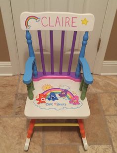 a child's plastic chair with the name claire on it and rainbows