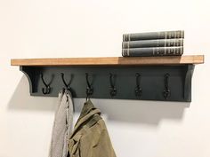 a coat rack with three books and two coats hanging on it