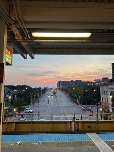 an empty city street at dusk with the sun going down