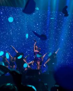 a group of people standing on top of a stage with their arms in the air